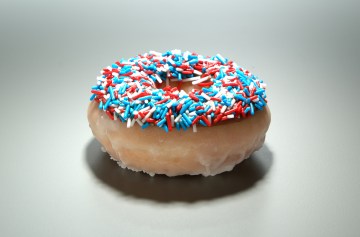 Chocolate glazed and multi-coloured sprinkled doughnut