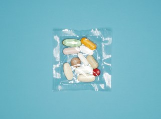 Sealed plastic packet of pills on blue background