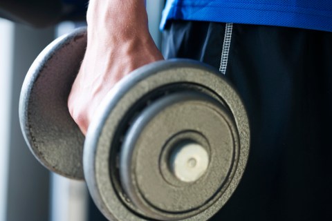 A young man lifting weights, close-up