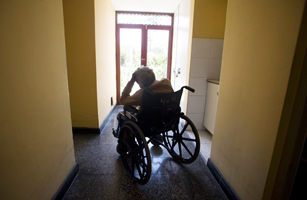 An elderly women rests on her wheel chair in a hall of the senil dementia building of the Canevaro old people's home in Lima