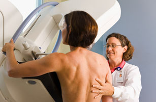 Medical technician preparing patient for mammogram