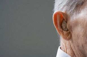 Close up of senior Hispanic man???s hearing aid