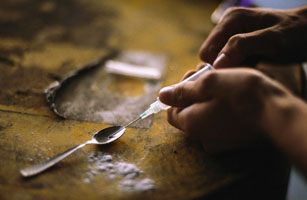 Person preparing syringe of crack cocaine