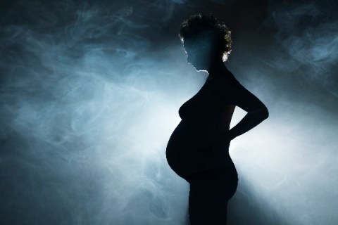 Pregnant woman surrounded by smoke