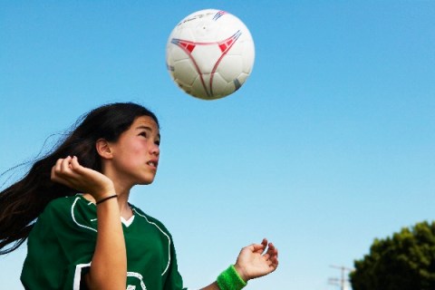 Girl heading soccer ball