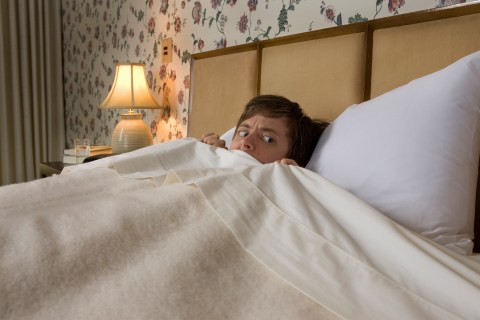 Man in bed with nervous look
