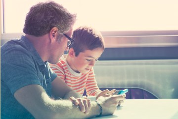 Father and son playing on phones