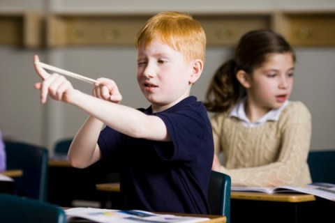 Boy with slingshot in classroom