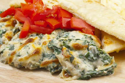 spinach dip with pita bread and peppers