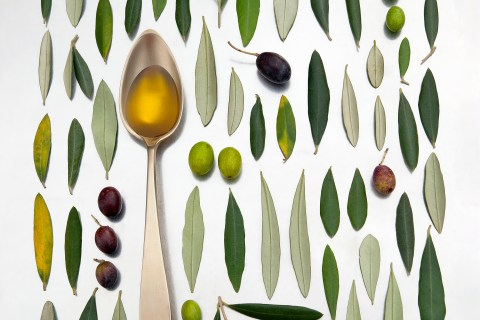 Olives, leaves and olive oil in a pattern