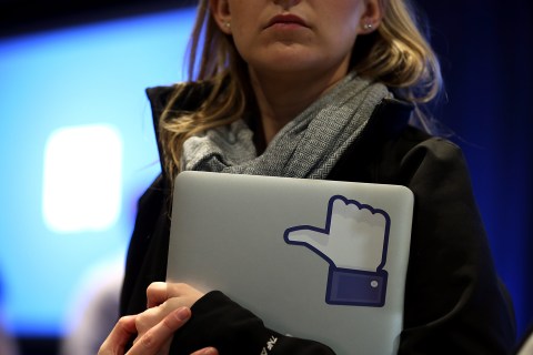 A Facebook employee holds a laptop with a "like" sticker on it at an event at Facebook headquarters in Menlo Park, Calif., on April 4, 2013.