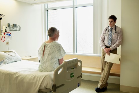 Doctor and mature male patient in discussion in hospital room