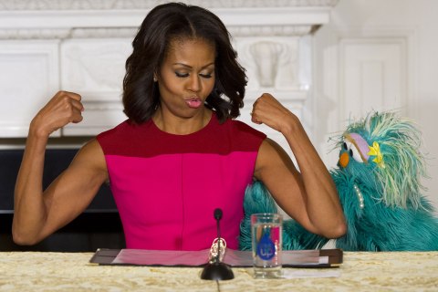 First Lady Michelle Obama flexes her muscles alongside Sesame Street character Rosita