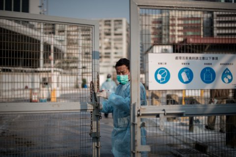 A security guard closes the gate of a live poultry market in Cheung Sha Wan before officials proceed to cull chickens in Hong Kong on Jan. 28, 2014.