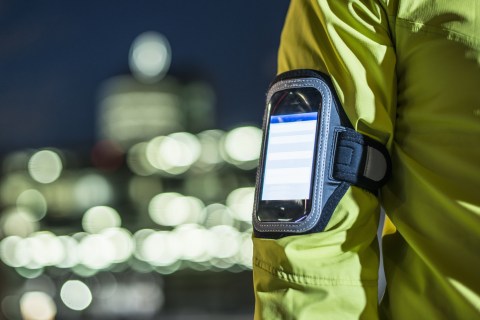 Runner wearing smartphone on arm in city